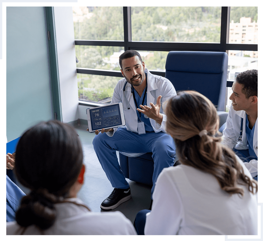 Doctors discussing medical data on a tablet.