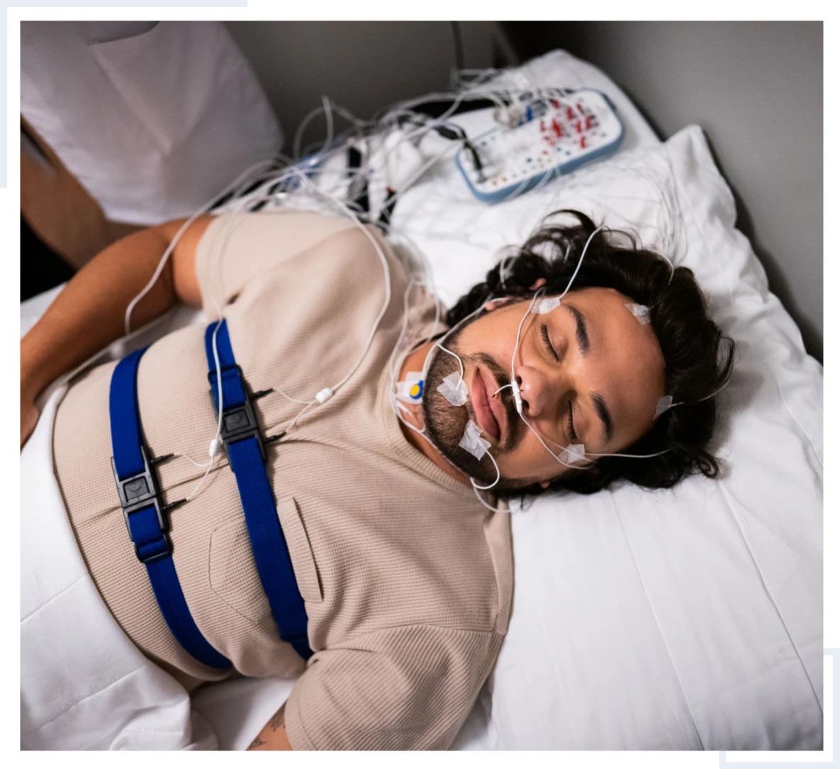 Man undergoing sleep study with sensors attached